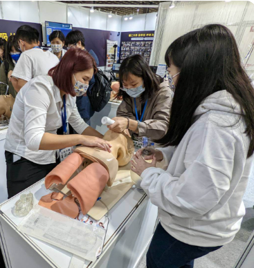 醫護人員指導學生練習臨床技能模型